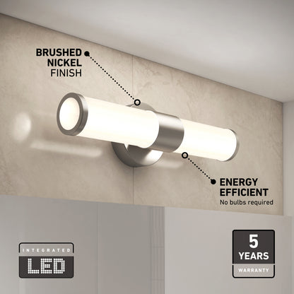 The Adina modern bathroom vanity light by Artika features a brushed nickel finish, integrated LED tube with 3 CCT options, energy efficiency, and a 5-year warranty. It is wall-mounted and shown on a beige tiled wall.
