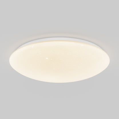 The Artika Empress 13 in. LED modern flush mount light, ceiling-mounted, glows softly against a light gray background. Its surface features tiny star-like dots for a subtle, starry effect. Choose from 3 CCT options for customizable ambiance.