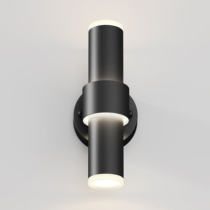 The Artika Dani modern LED indoor-outdoor wall light 5 CCT features two cylindrical fixtures on a circular base, with up and down lighting that emits soft white light, perfect for brightening light-colored walls.