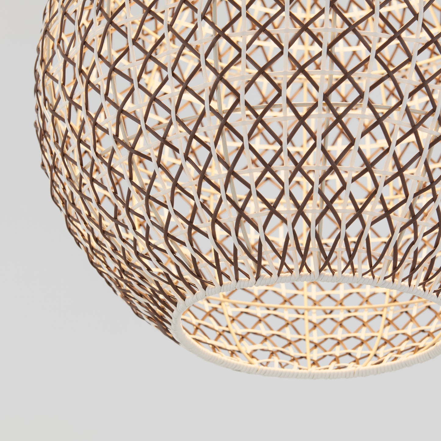 A close-up of the Artika Benson LED pendant light 5 CCT, featuring an intricate woven lattice design and a warm glow, set against a plain light gray background.