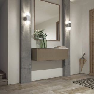 Modern entryway with light wood flooring, a floating console topped with a green vase of leafy branches, a large mirror, woven mat, umbrella stand, and two Artika Lennox indoor-outdoor LED wall lights (3 CCT) in matte black beside the stairs.