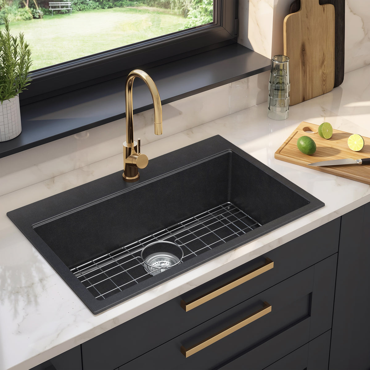 Artika Baycrest 33″ black sink with gold faucet and cutting board on white marble, featuring limes.