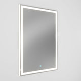 A rectangular wall-mounted mirror with a built-in LED light frame glows softly against a plain white background. A small touch button is visible at the lower center of the mirror.