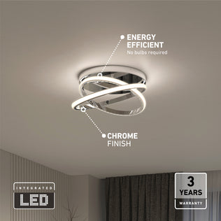 The Orbia modern LED flush mount light 3 CCT by Artika is mounted on a white ceiling. Labels note energy efficiency, chrome finish, integrated LED, and display a 3-year warranty badge in the lower right corner.