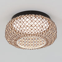 The Artika Benson 15 in. LED flush mount light features a round, woven rattan shade with a visible inner white diffuser and lattice pattern, mounted flush to a plain white ceiling. Offers 5 CCT options for customizable lighting.