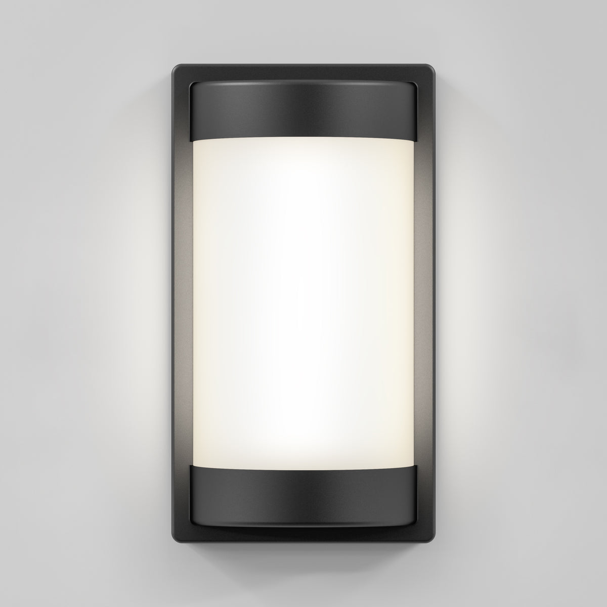 The Artika Fogo modern LED indoor-outdoor wall light 5 CCT features a frosted cylindrical glass panel and black metal frame, casting a soft white glow against a light gray wall.