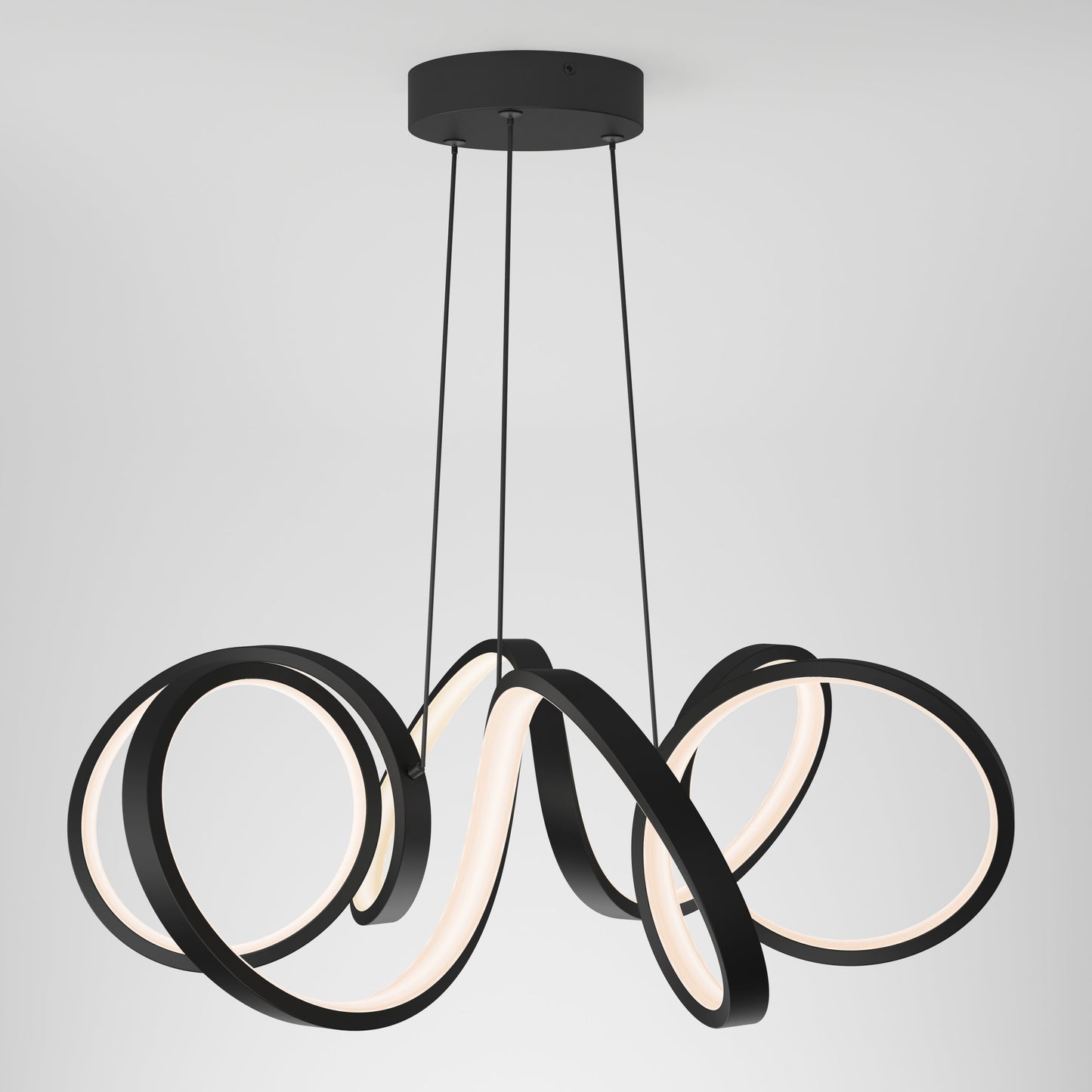 The Artika-CAN-dev Swirl Ribbon LED pendant light features three black, looping LED rings suspended by thin black cables from a round black base, creating a modern look against a plain white background.