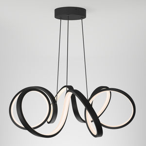 The Artika Swirl Ribbon LED pendant light features three intertwined black LED rings suspended by cords, creating a modern, sculptural look against a plain white background.