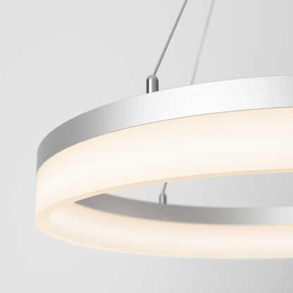 Close-up of the Artika Optical LED pendant light 3 CCT, featuring a sleek metallic frame and glowing frosted ring, suspended by thin wires against a neutral background.