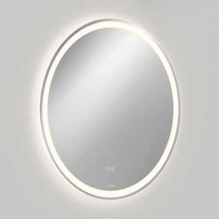 The Artika Ayla 28 in. LED mirror features a 3 CCT illuminated light ring, integrated defogger, and two blue touch control buttons, shown wall-mounted against a plain light gray background.