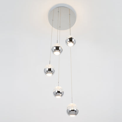 The Artika Oracle modern 5-light LED pendant features five chrome-finished spheres hanging at varying lengths, casting white light against a plain white background.