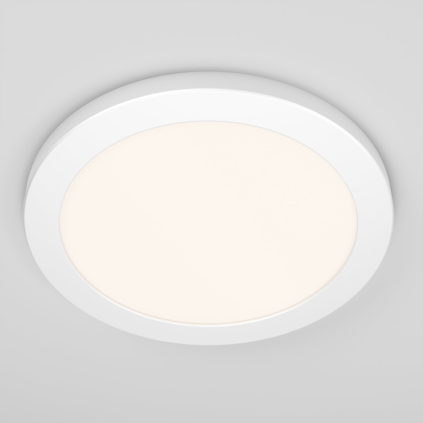 A close-up of the Artika Europa Disk 9 in. LED modern flush mount light with 3 CCT, installed on a plain light gray ceiling and emitting a soft, warm glow.