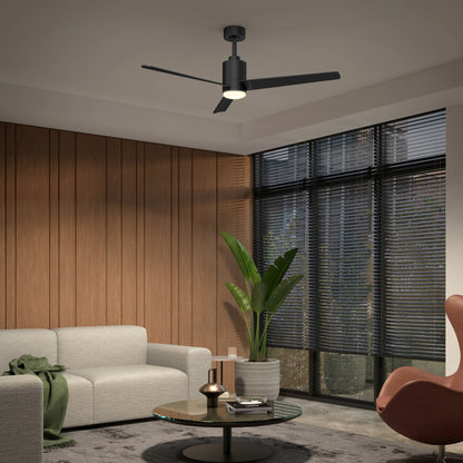 A modern living room with a gray sofa, round glass coffee table, large potted plant, wooden wall panels, and large windows with blinds. The Artika Ellison 52 in. LED modern ceiling fan with remote completes the contemporary decor.