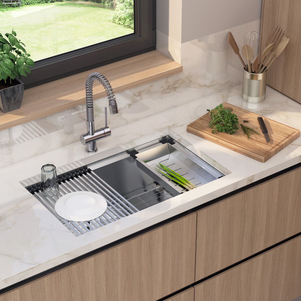 A modern kitchen sink with a marble countertop, a faucet, a dish rack holding a white plate and glass, utensils in a holder, a cutting board with chopped herbs, and a potted plant by a window.
