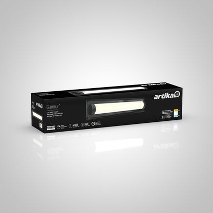 A black rectangular box for the Artika Glamour LED bathroom vanity light 3 CCT is shown against a grey background, featuring an image of the lamp and details about energy efficiency and lighting.