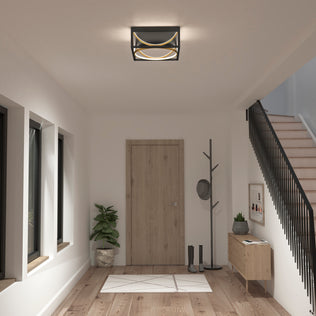 Modern entryway with wooden door, coat rack, plant, table, stairs, and Artika Luxury 13 in. Modern LED flush mount ceiling light.