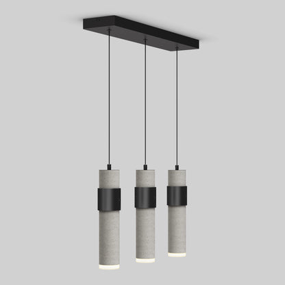 The Artika Barden 3-light LED pendant features three cylindrical concrete lampshades suspended from a black rectangular ceiling mount by slim black cords, shown here against a plain light gray background.