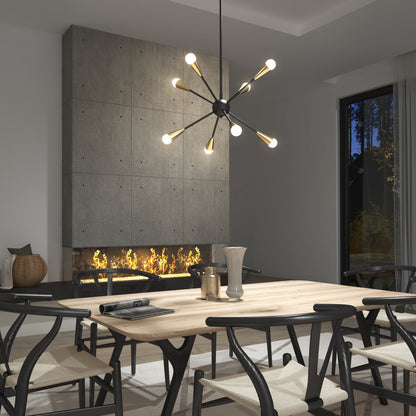 A modern dining room features a light wood table, black chairs with white seats, a concrete fireplace with a fire burning, and the Artika Wayden modern LED pendant light 3 CCT hanging above. A large window reveals trees outside.