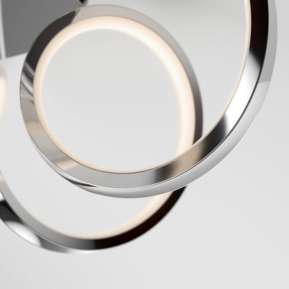Close-up of two intertwined Swirl Ribbon LED pendant lights by Artika-CAN-dev, featuring a modern chrome finish. The integrated LEDs emit a soft, even glow against a plain background.