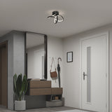 A modern entryway with a floating wooden console, a large mirror, and wall hooks holding umbrellas and bags. A plant sits on the floor, and a sculptural ceiling light fixture illuminates the space.