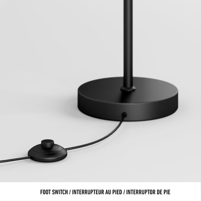 A close-up of the Artika Coda modern LED floor lamp 5CCT’s black base features a round foot switch with cord. Text below: FOOT SWITCH / INTERRUPTEUR AU PIED / INTERRUPTOR DE PIE.
