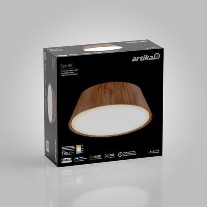 A product box for the Artika Dunham 15 in. LED flush mount light 5 CCT shows the wood-finished fixture on the front against a black background, with product details and icons displayed below.