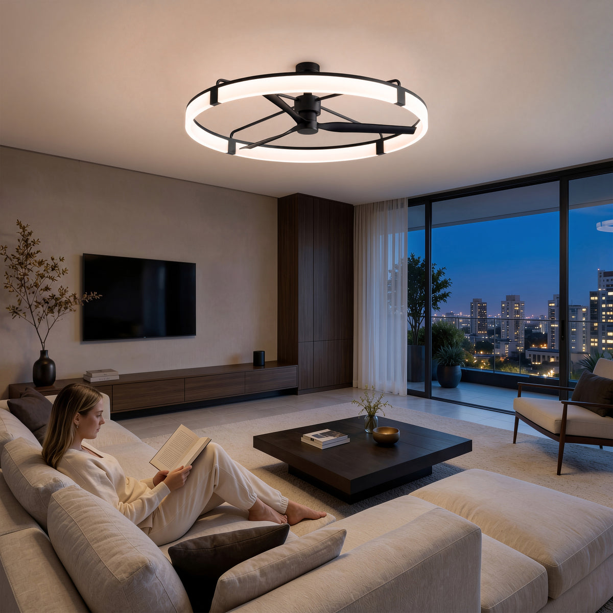 A woman reads on a beige sofa in a modern living room with city views, lit by the Artika Sunnyvale 52 in. LED ceiling fan.