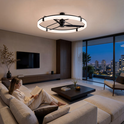A woman reads on a beige sofa in a modern living room with city views, lit by the Artika Sunnyvale 52 in. LED ceiling fan.