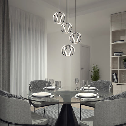 A modern dining room features a round glass table set for four with gray upholstered chairs. Overhead, the Artika Vivaldi LED 4-light pendant adds elegance, while sheer curtains and a plant complete the refined decor.