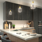 Modern kitchen with dark wood cabinets, marble countertops, pendant lights, and various utensils and decor items neatly arranged on the counter and shelves. Two chairs face the island countertop.