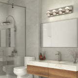 Modern bathroom with a glass shower, white toilet, large mirror, marble countertop, wood vanity, and minimal decor. Four-bulb vanity light fixture is mounted above the mirror.