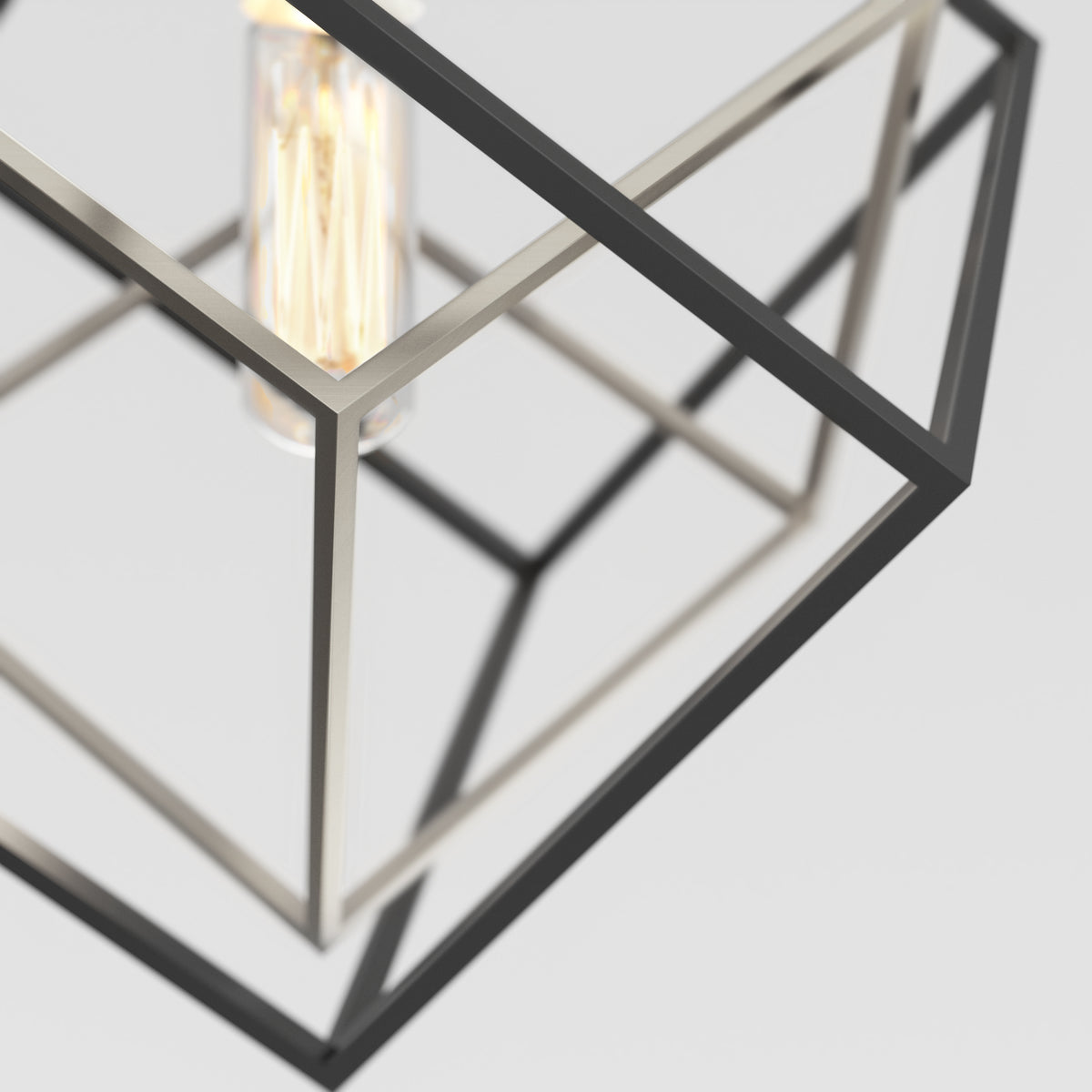 A close-up of the Artika Imperium Single pendant light, showcasing intersecting black and silver frames with an exposed vintage-style bulb, set against a plain white background.