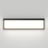 A rectangular, modern wall light fixture with a black frame and a frosted white panel, mounted on a light gray wall and emitting a soft, even glow.