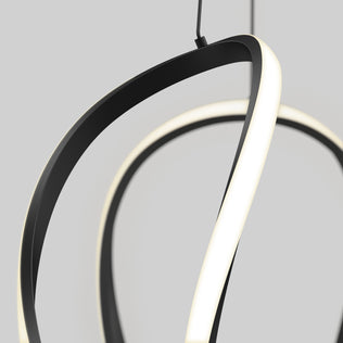 Close-up of the Vivaldi Big LED pendant light 5 CCT by Artika, featuring sculptural, twisting black and white bands, suspended against a plain gray background.