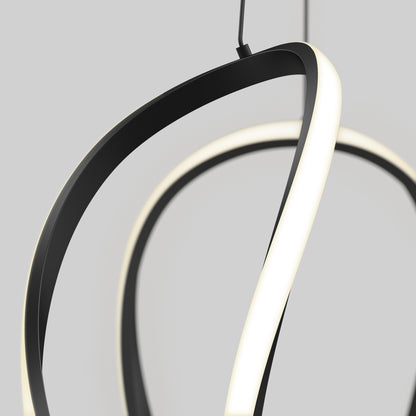 Close-up of the Vivaldi Big LED pendant light 5 CCT by Artika, featuring sculptural, twisting black and white bands, suspended against a plain gray background.