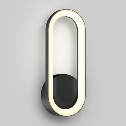 The Artika Aiden modern LED indoor-outdoor wall light 5 CCT features an oval-shaped illuminated LED ring on a round black base, displayed against a plain light gray background.