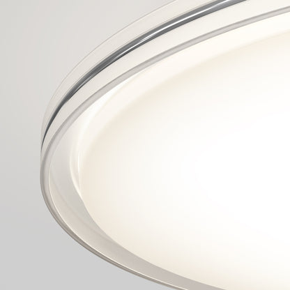 Close-up of the Artika Astrid 16.5 in. LED flush mount light 5 CCT with remote, featuring a smooth frosted white cover and metallic rim, emitting bright even light against a neutral background.