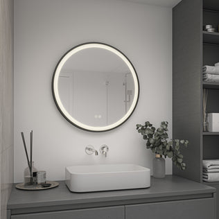 A modern bathroom with Artika’s Mateo 28 in. LED mirror, adjustable CCT, defogger, square sink, shelves, and vase with leafy branches.