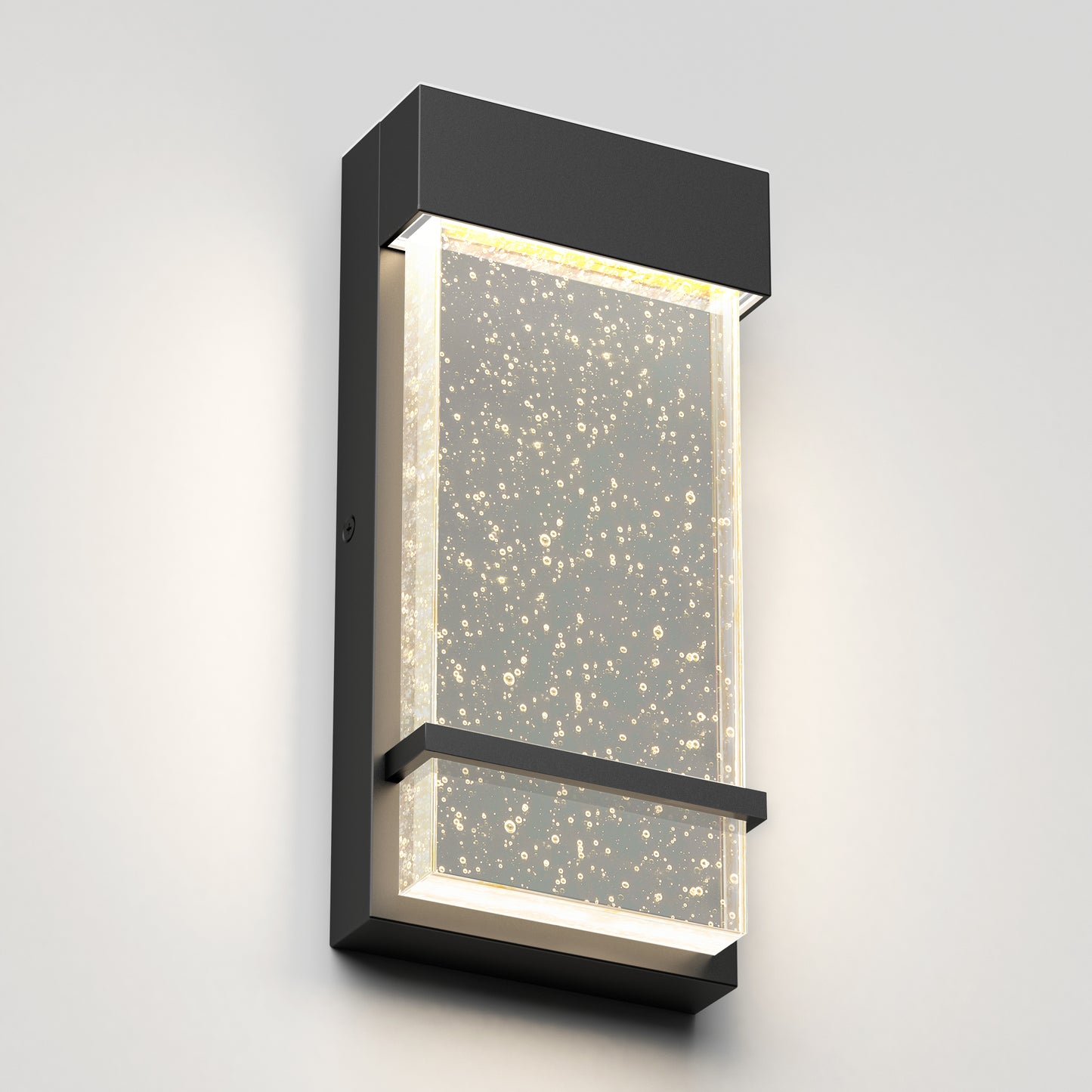 The Skyler indoor-outdoor LED wall light by Artika features a modern rectangular black metal frame and a clear textured panel with bubble details, casting soft white light while mounted on a light gray wall.