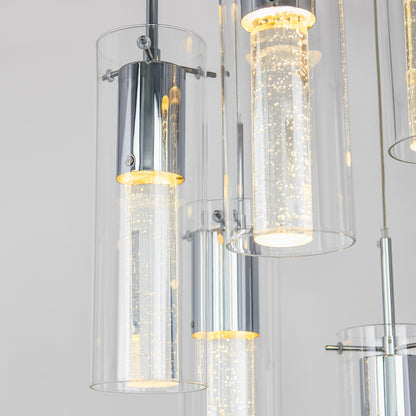 Close-up of the Artika Essence 5-light LED pendant, featuring cylindrical glass shades with bubble-filled inner tubes that emit a warm glow against a plain light background.