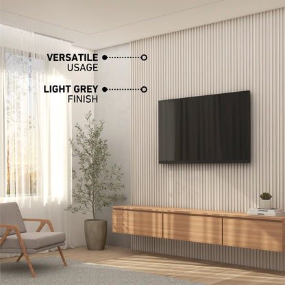 Modern living room with a wall-mounted TV, wood console, plant, and armchair. Text highlights “Versatile Usage” and “Light Grey Finish” on Artika’s Panolok 30.67 ft wall panel kit (pack of 8) against vertical slatted paneling.