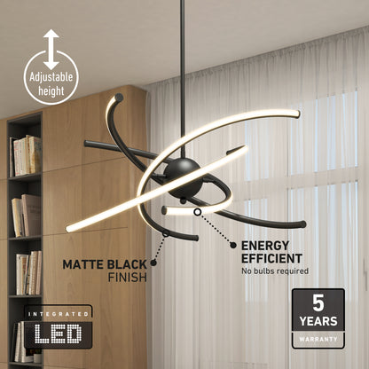 The Artika Silvio LED pendant light 3 CCT, a modern black chandelier with curved integrated LED bars, hangs from a living room ceiling, featuring adjustable height and energy efficiency, alongside large windows and sheer white curtains.