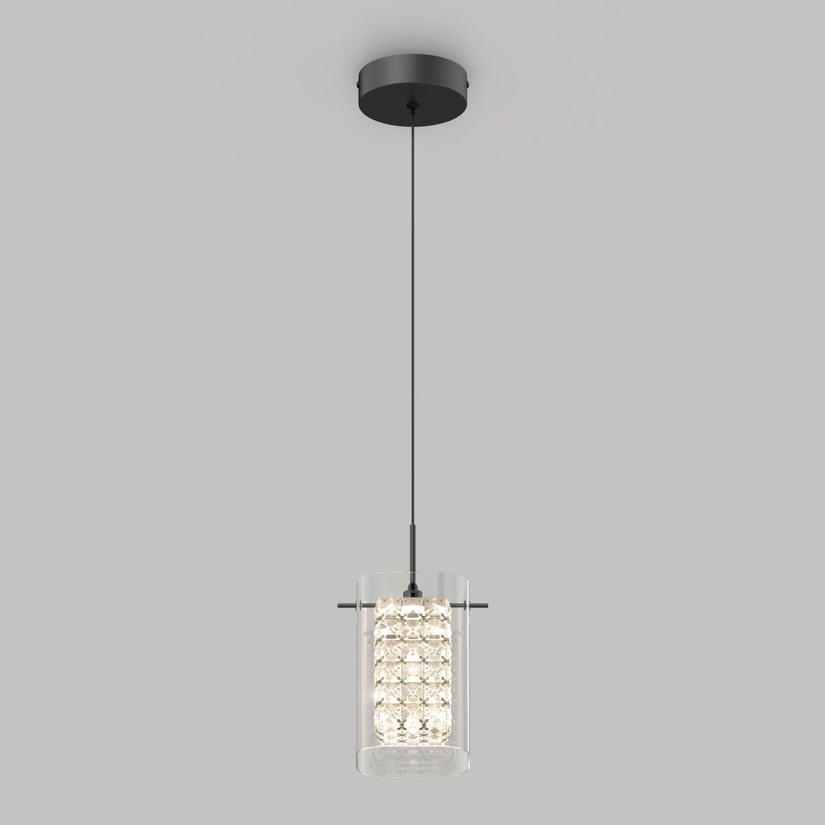 A modern pendant light fixture with a cylindrical glass shade, featuring a cluster of small lights inside, hangs from a black cord attached to a round ceiling mount against a plain light gray background.