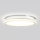 A modern, round, flush-mounted ceiling LED light fixture emits a soft, even glow against a white ceiling background.