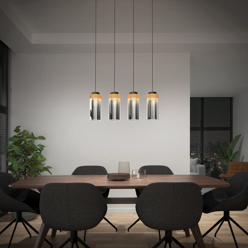 A modern dining room features a round wooden table, six dark upholstered chairs, a green potted plant, and the Artika Hanson 4-light LED pendant above; large windows reveal a nighttime city view.