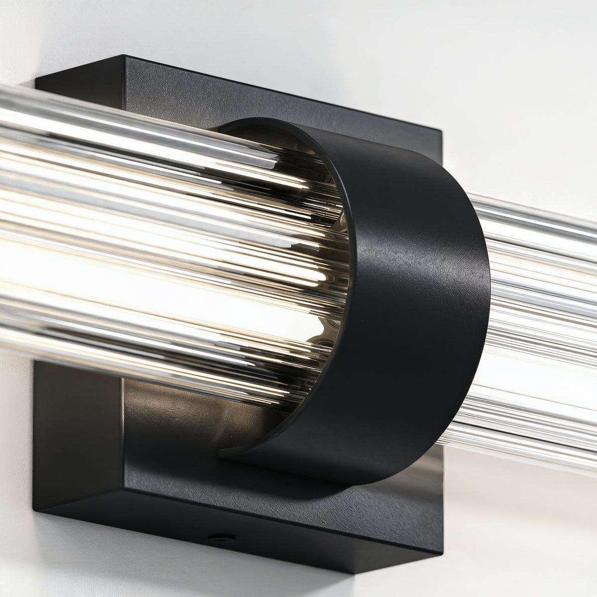Close-up of the Artika Dorado 27 in. LED Wall Vanity with black base and clear cylindrical glass rods.