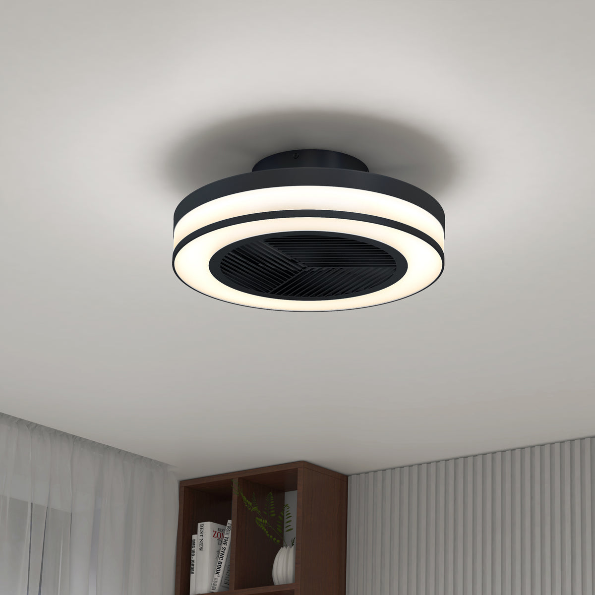 A modern ceiling fan with integrated circular LED lights is mounted on a white ceiling in a minimalistic room with a bookshelf, sheer curtains, and vertical wall paneling.