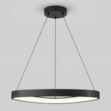 A modern, circular pendant light with a black frame hangs from the ceiling by three thin, black cables, emitting soft white light against a light gray background.
