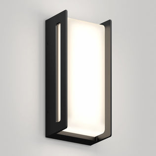 The Artika Ryker smart RGB indoor-outdoor wall light features a minimalist rectangular black metal frame and frosted white panel, shown mounted on a light gray wall—a modern, geometric design.