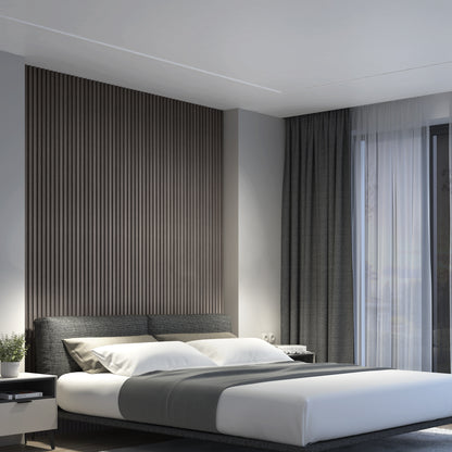 A modern bedroom with a neatly made bed, gray headboard, and gray-striped accent wall. Floor-to-ceiling curtains cover large windows, and soft natural light fills the room. A small plant sits on the bedside table.